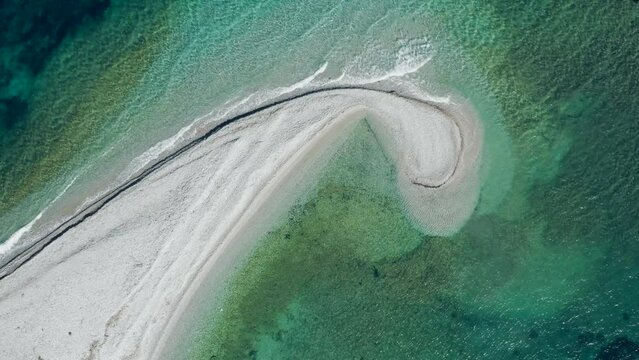 Beautiful drone shot of sandbank like a comma in green gradient sea, Amorgos, Cyclades Island in Greece.