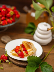 Thin pancakes stacked with strawberries between layers