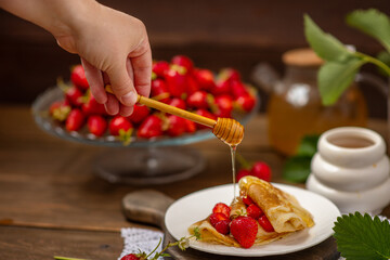 Thin pancakes stacked with strawberries between layers