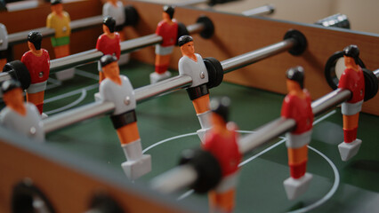 Close up of players on foosball game table for fun activity in office after work. Table with...