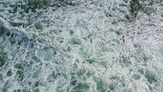 Surf with ocean waves crashing against a coral reef view from above. Sri Lanka.