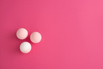 Composition of pastel pink bath bombs over fuchsia background