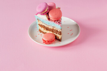piece of cake with pink and blue decor on white plate on pink background
