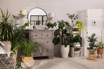 Fototapeta na wymiar Stylish bathroom interior with modern furniture and beautiful green houseplants