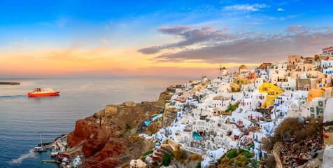 Fantastic Sunset view of traditional Greek village Oia on Santorini island, Greece, Europe. luxury travel. Passenger ferry sailing to the island. Summer holidays. Travel concept background.