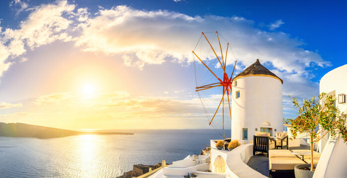 Picturesque Sunset view of traditional Greek windmill on Santorini island, Greece, Europe. luxury travel. Summer holidays. Travel concept background.