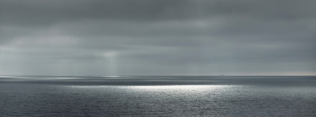 Panoramic view of the Baltic sea during the storm. Dramatic sky, sun rays through the dark clouds....