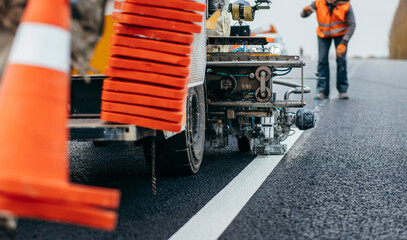 Workers applying new road markings, outside the city