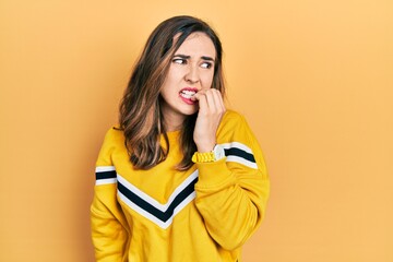 Young hispanic girl wearing casual clothes looking stressed and nervous with hands on mouth biting...