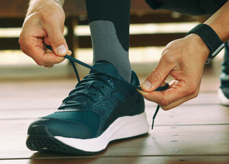 Fototapeta premium Guy preparing for running and laces up on the sneakers