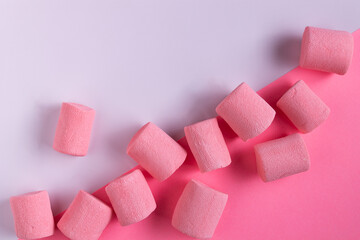 pink marshmallow lies on white and pink paper, space for text