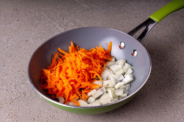 fried carrot lies in a frying pan on a gray background, close-up