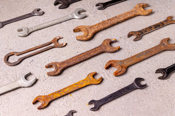 old rusty tools lie on gray plaster, pattern