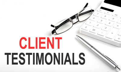 CLIENT TESTIMONIALS Concept. Calculator,pen and glasses on the white background