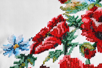 Beautiful floral bead embroidery on white fabric, closeup