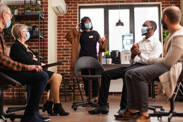 Woman expressing anger management issues at aa meeting, wearing face mask. People attending group...