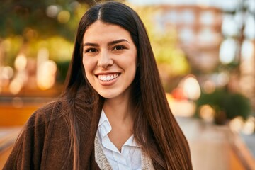 Obraz premium Young hispanic woman smiling happy standing at the city.