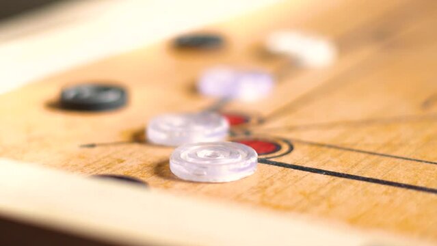Closeup shot of Carrom coins on a carrom board. Indoor board game background. Carrom pieces on board in India