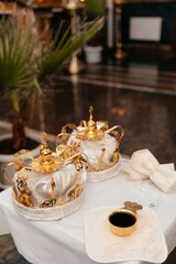 golden crown of white fabric with a pattern lie on a table