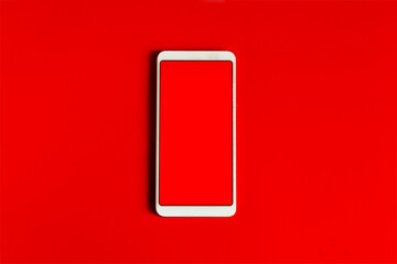 The concept of online shopping. A white phone with a bright red flat screen on a red background.