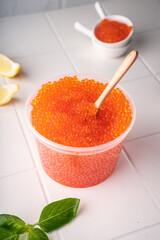 Natural red caviar from trout and salmon. A pure product, a delicacy. On a white background in a beautiful presentation