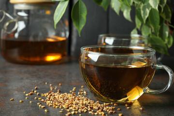 Concept of hot drink with buckwheat tea on dark textured table
