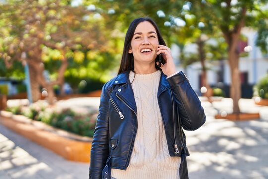 Young woman smiling confident talking on the smartphone at park