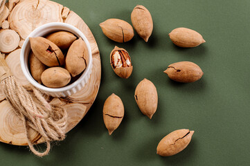 Dried pecans scattered on a green background