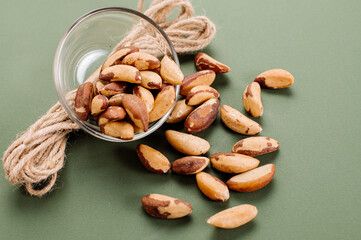 Peeled Brazil nuts scattered on a green background
