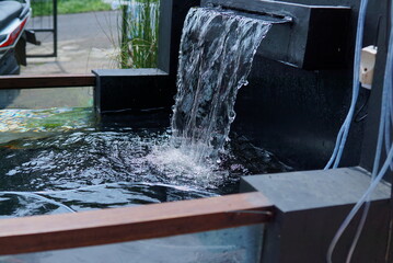 man made fish pond waterfall. Water in the fountain. water running down the stairs. moving water - a view of a waterfall in the park.