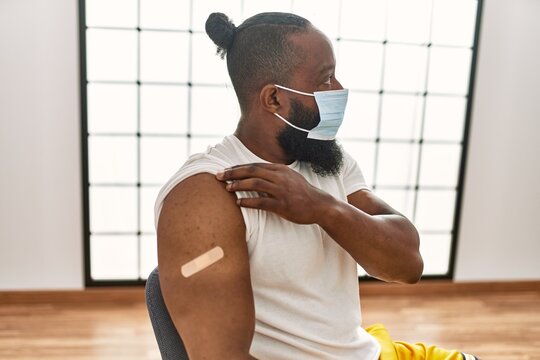 Young African American Man Showing Band Aid For Covid-19 Vaccination At The Clinic.