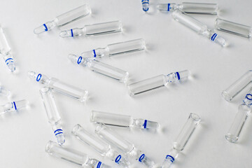 randomly lying ampoules with medicines on a white background