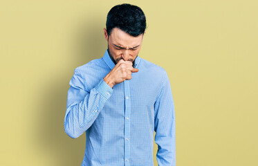 Hispanic man with beard wearing casual business shirt feeling unwell and coughing as symptom for cold or bronchitis. health care concept.