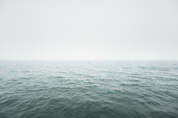 Panoramic view of Baltic sea from sandy shore. Thick white fog, mist. Waves, water splashes....