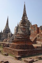 Fototapeta premium Adventure of exploring the ruins of red brick Wat Phra Si Sanphet temple (vertical image), Ayutthaya, Thailand