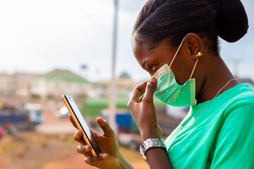girl wearing face mask using mobile phone