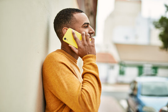 Young african american man smiling happy talking on the smartphone at the city.