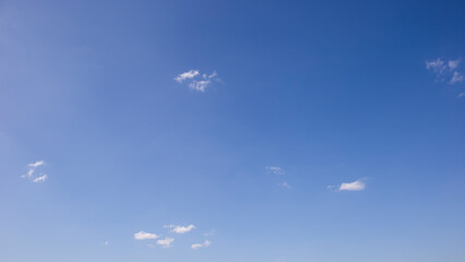 Naklejka na ściany i meble Cloudy sky on a bright blue day background.