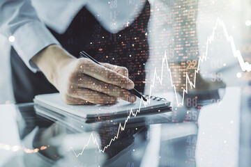 Multi exposure of abstract creative financial chart with world map and with man hand writing in notebook on background, research and analytics concept
