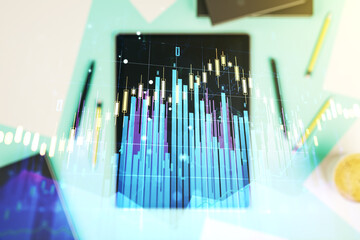 Abstract creative financial graph and modern digital tablet on desktop on background, top view, financial and trading concept. Multiexposure