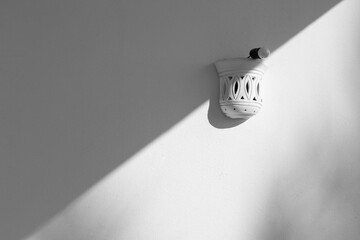 White wall with grey shadow . Half white half grey. Summer light. Abstract monochrome background.