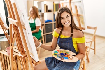 Mother and daughter smiling confident drawing at art studio