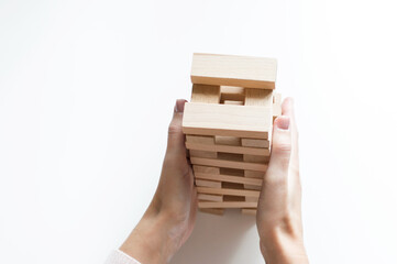 Board game geng or tower on a white table. The hand of a man collects it