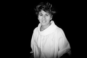 Woman With Short Disheveled Hair On A Black Background. 40-Year-Old Woman Posing For International Women's Day, March 8. Warrior Woman.