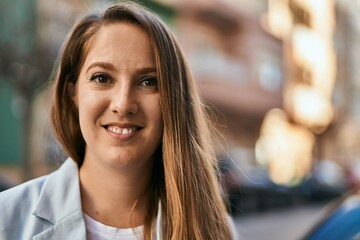 Obraz premium Young blonde businesswoman smiling happy standing at the city.