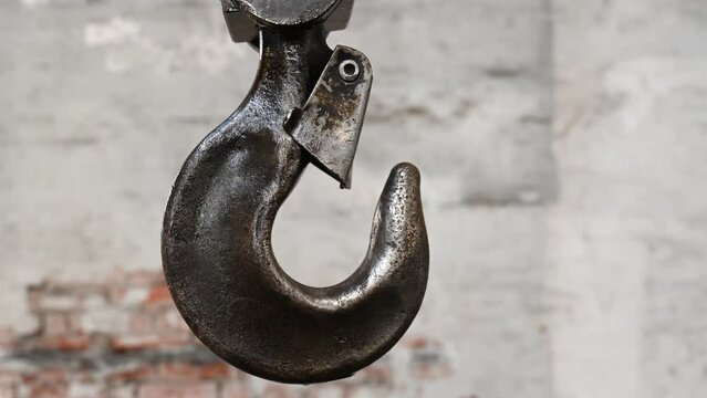 Huge steel hook on crane in factory. Industrial metal hook, close up. Old crane hook in harbor. Industry.