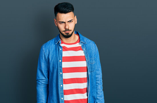 Young hispanic man with beard wearing casual denim jacket skeptic and nervous, frowning upset because of problem. negative person.