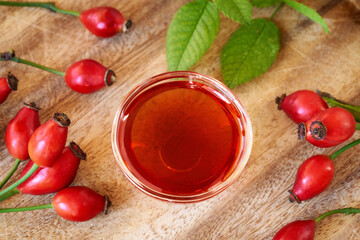 A bottle of rose hip seed oil with fresh rosehips, top view