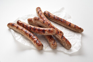 Tasty roasted sausages against white background