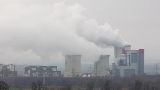 Distant panorama on smoking coal power plant in Bogatynia. Footage taken on a cloudy day, soft light.
